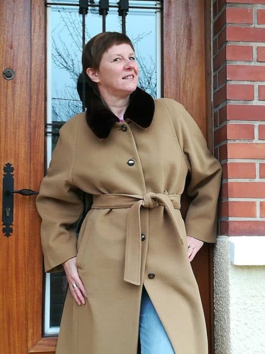 femme souriant en manteau beige ceinturé