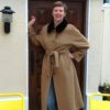 femme souriant en manteau beige avec ceinture