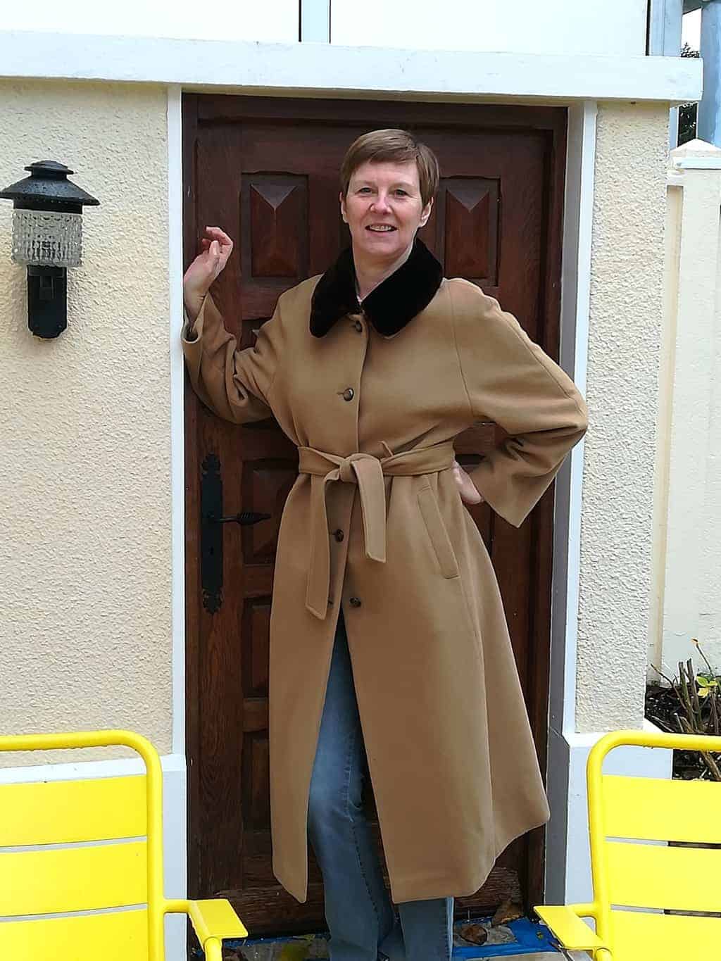 femme souriant en manteau beige avec ceinture