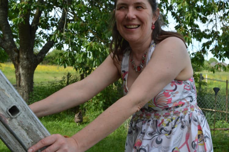 femme en robe d'été sur échelle souriant